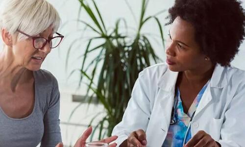 Primary Care Nurse Practitioner Consulting with Adult Female Patient