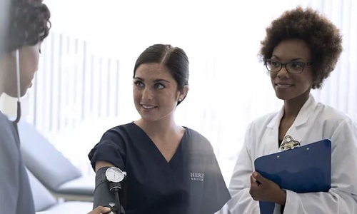 Nurse Teacher Showing Nursing Student How to Take Blood Pressure