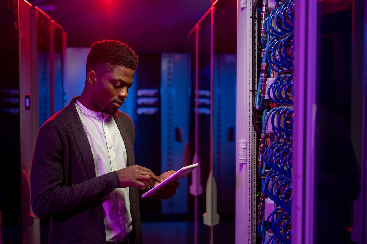 Cyber Security Analyst Using Tablet in Server Room