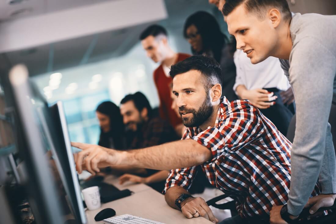 Software Engineer Pointing at Coding Project with Team Software Engineer Pointing at Coding Project with Team