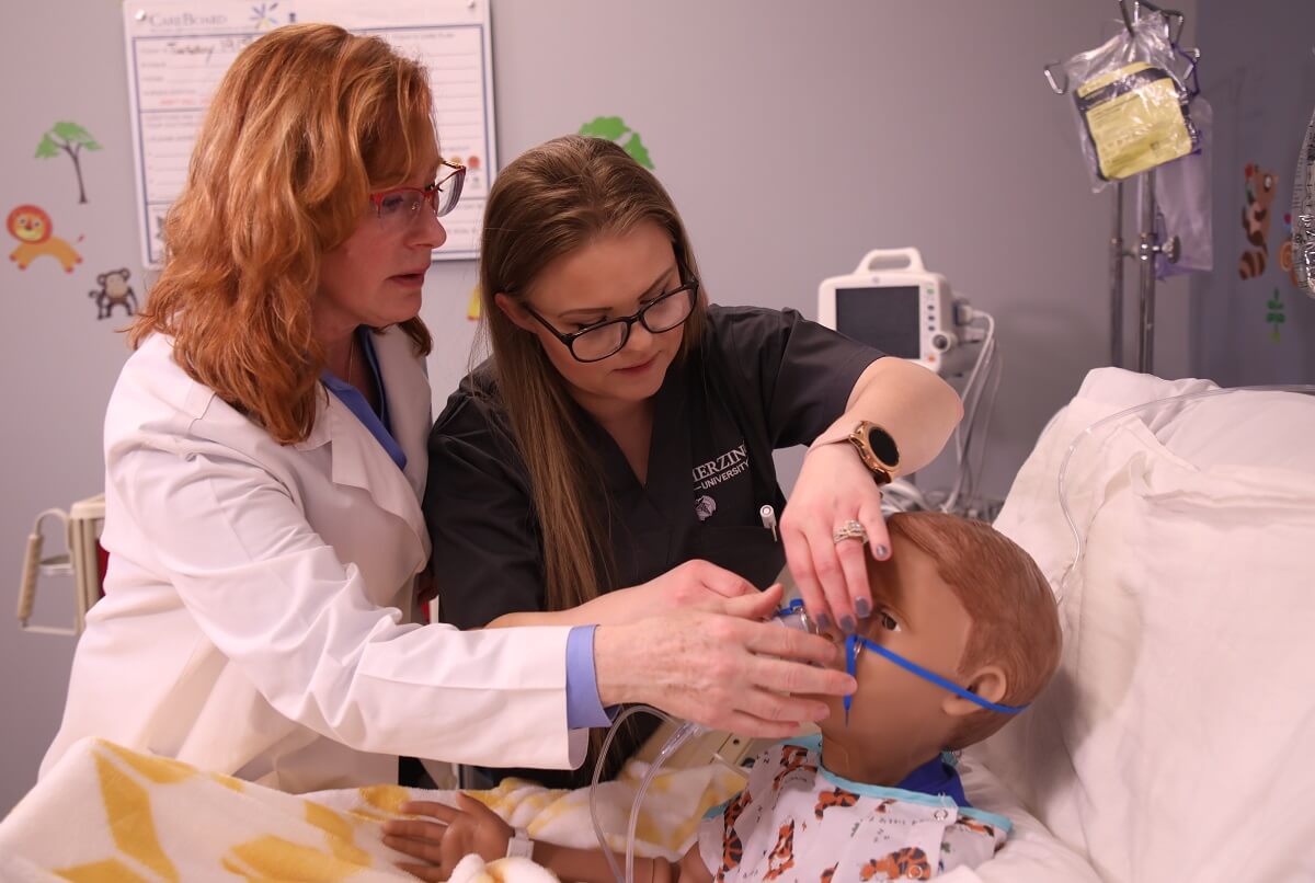 Nursing Student with Teacher Learning How to Apply Oxygen Mask LPN to RN Nursing Student with Teacher Learning How to Apply Oxygen Mask
