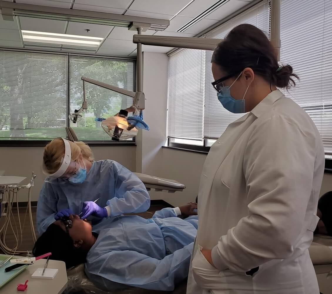 Dental Hygienist Student at School Under Supervision of Instructor