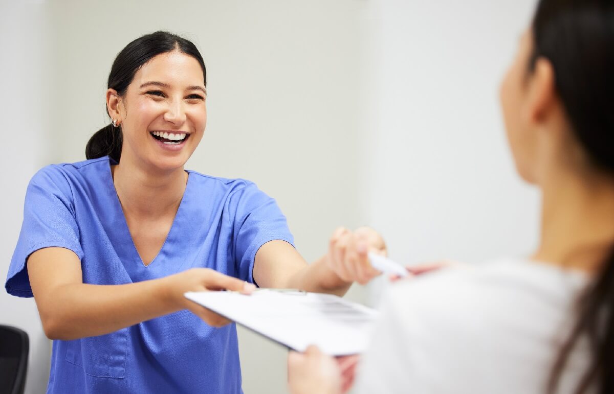 Smiling Medical Assistant Taking Patient History