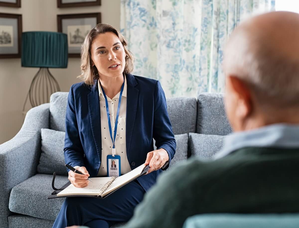 Female Social Worker Speaking with Elderly Client Female Social Worker Speaking with Elderly Client