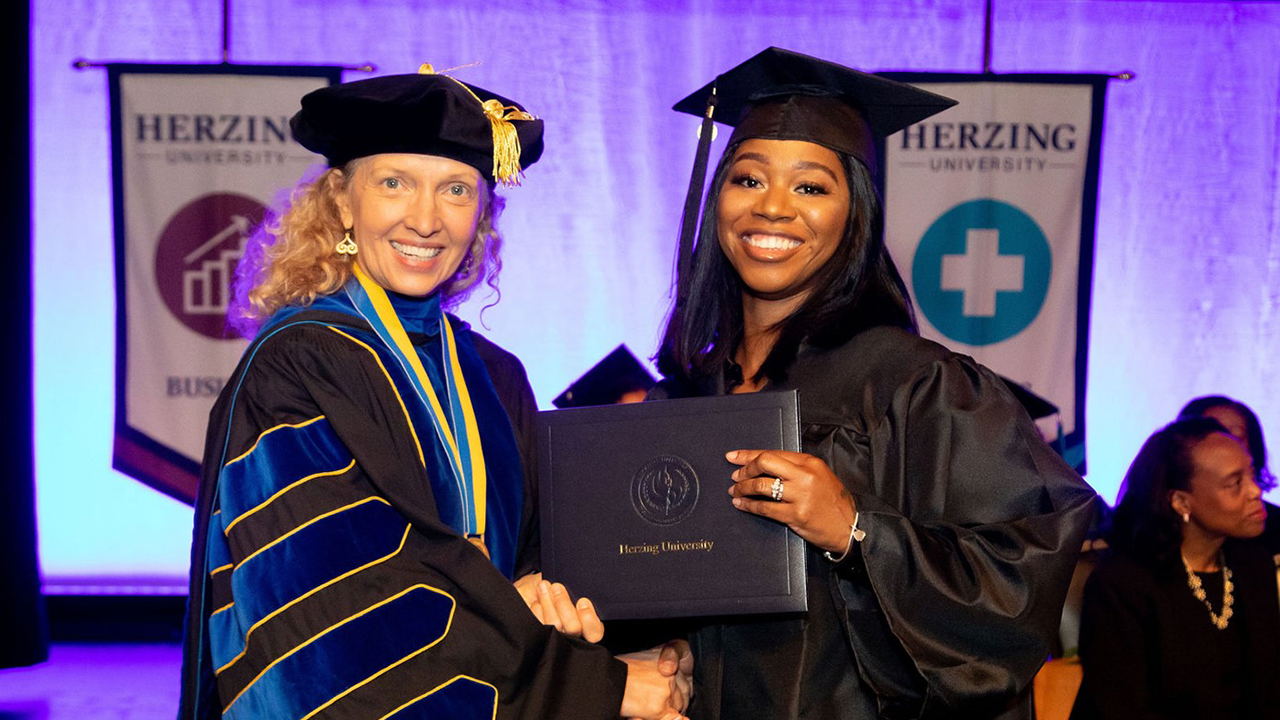 Renee Herzing with Herzing University Graduate Holding Degree