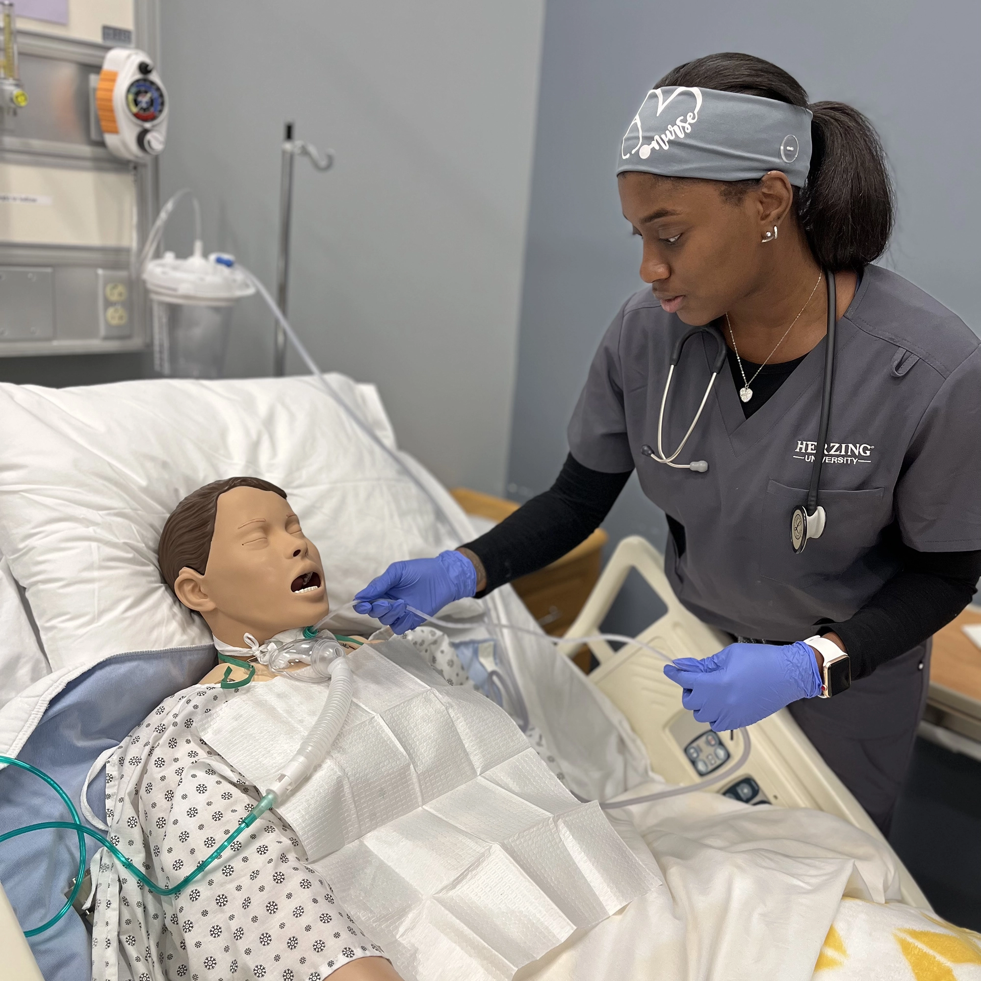 Nursing student practices patient care skills using a simulation mannequin at Herzing University Brookfield campus.