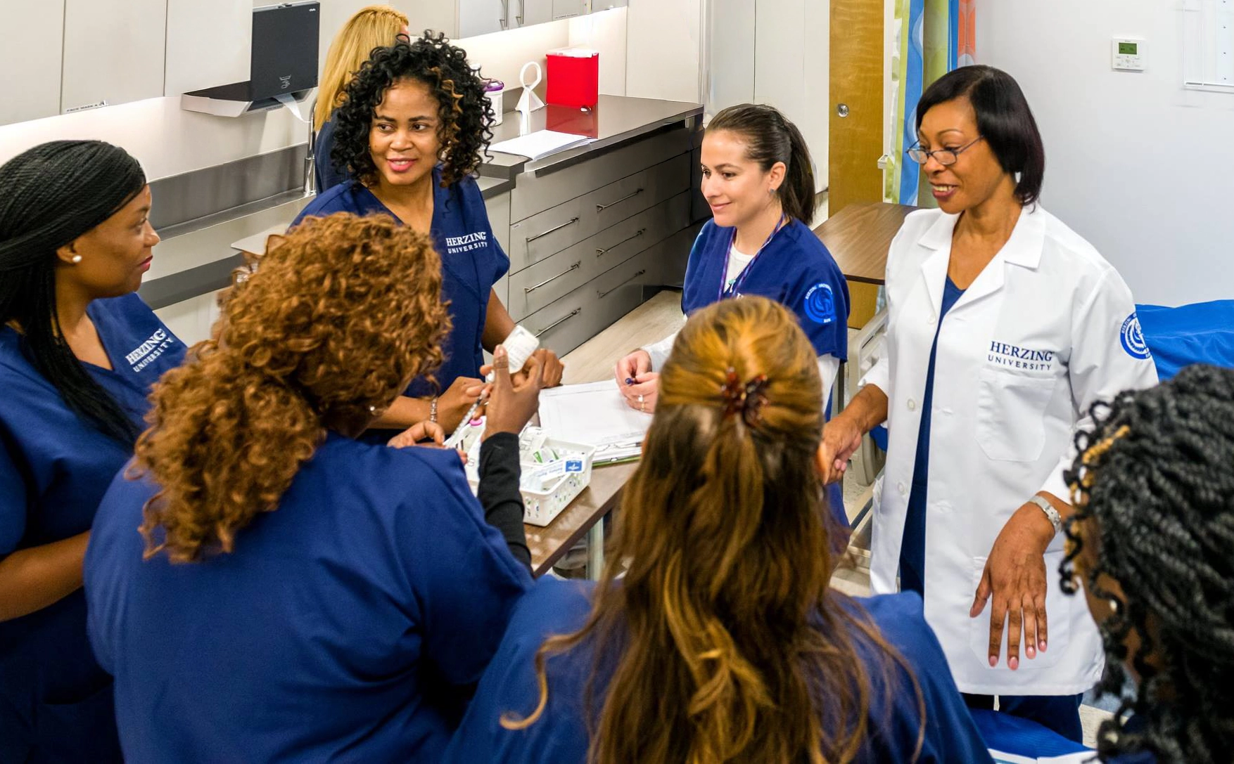 Herzing University Atlanta nursing students practicing in a skills lab with instructor guidance.