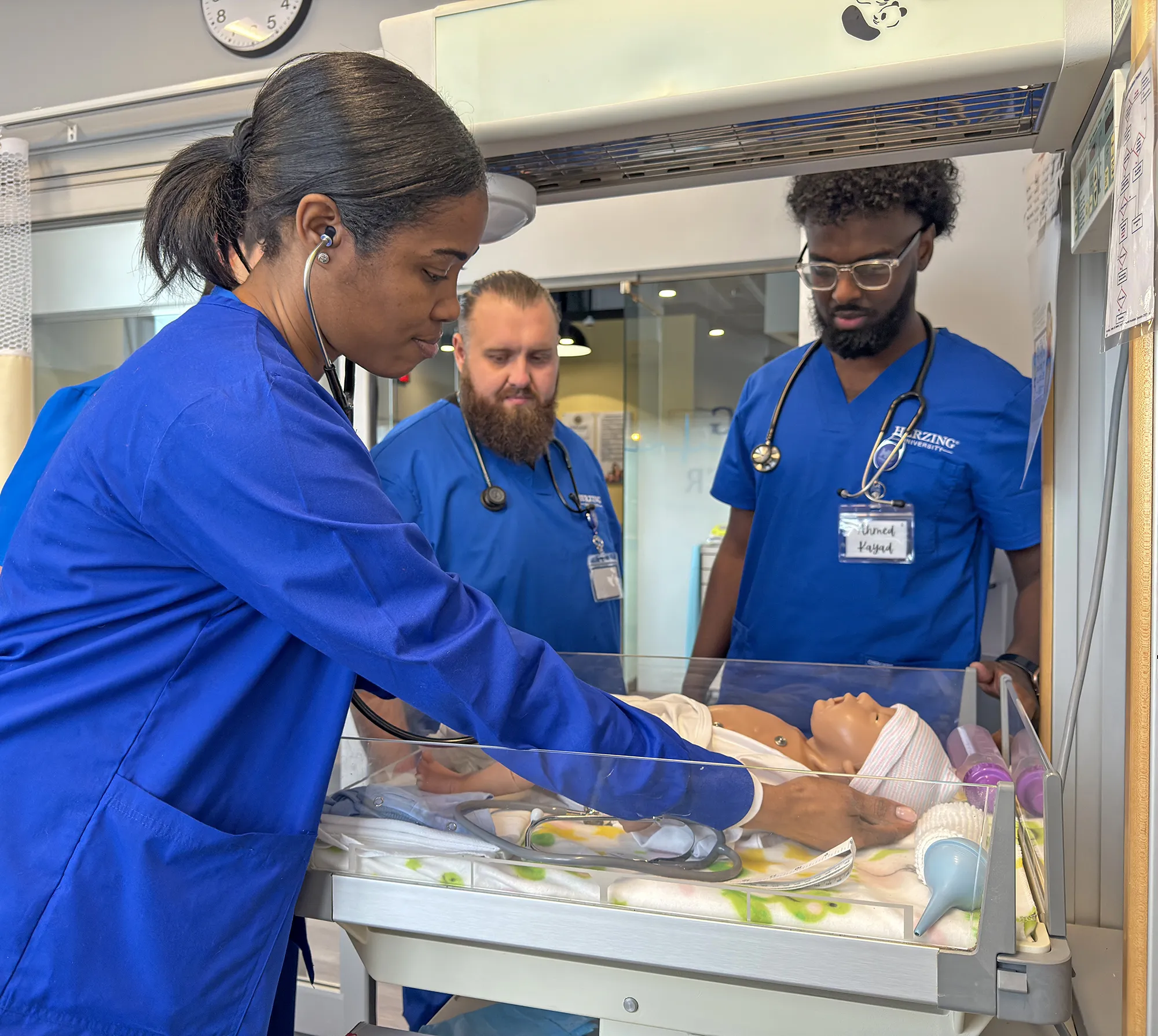Herzing University nursing students practice newborn care with an infant simulator in a neonatal simulation lab during hands-on clinical training.