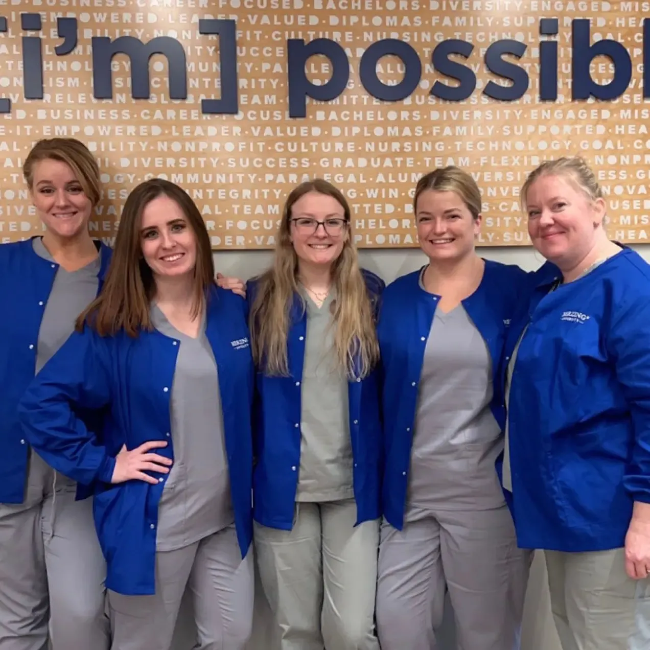 Online BSN intensive students in gray scrubs smiling
