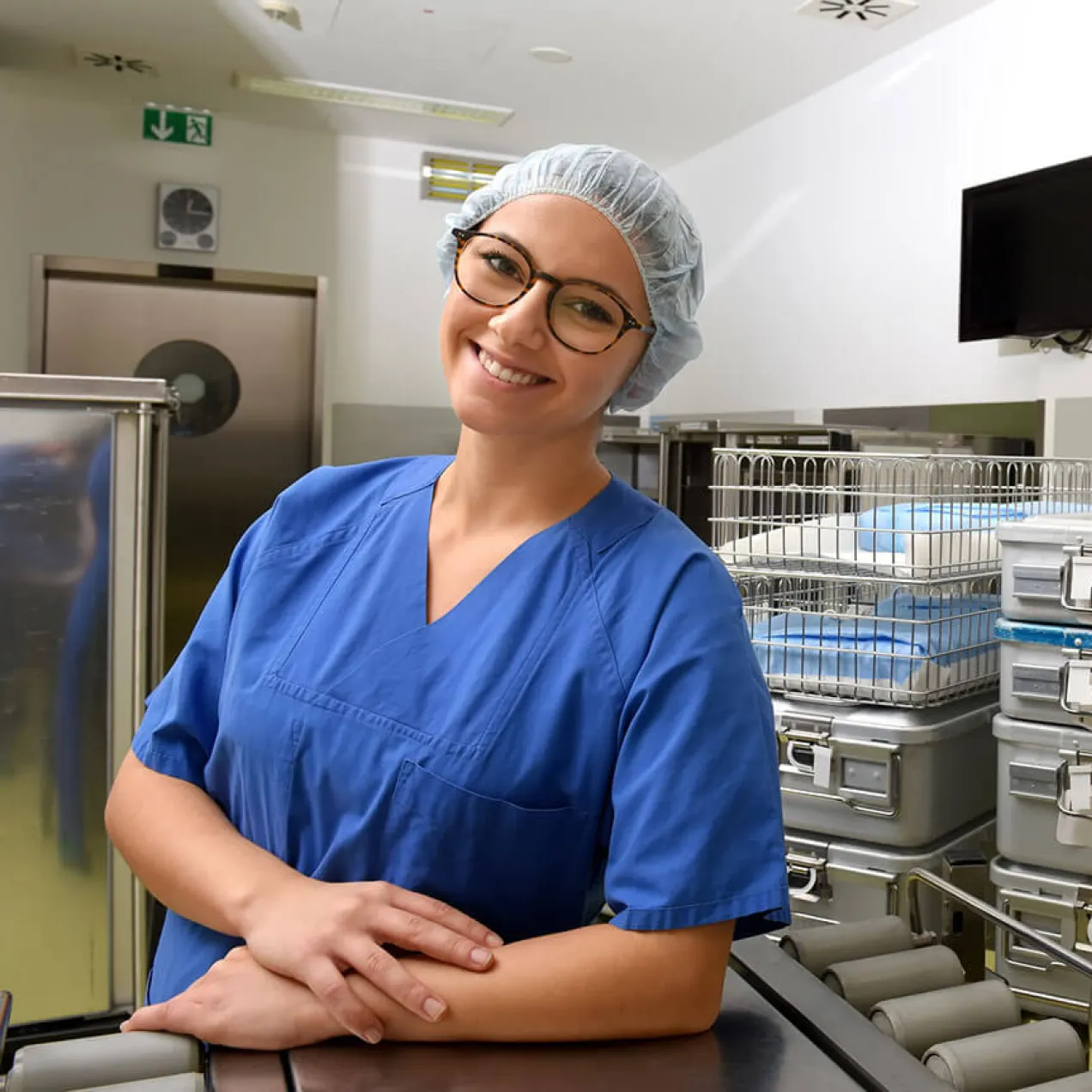 Sterile processing technician in lab wearing PPE posing and smiling for photo