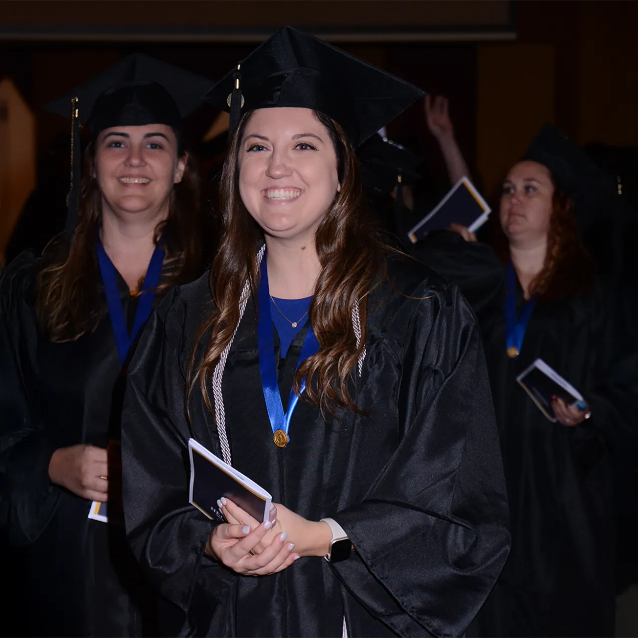 Herzing university graduate wearing cap and gown.