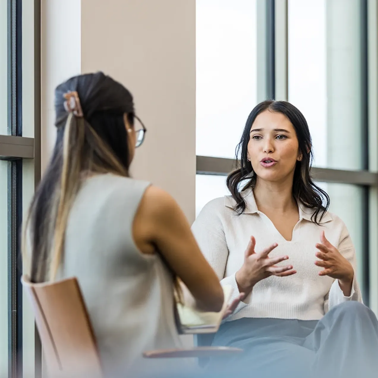 Two students having a one-on-one discussion, practicing interpersonal communication skills.