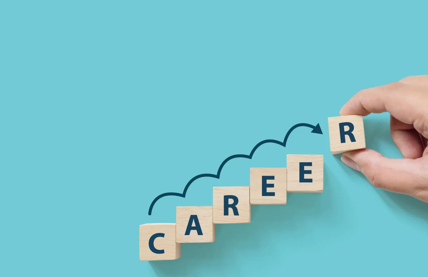 Hand putting wooden cube block on blue background with word CAREER. Business career planning growth to success concept