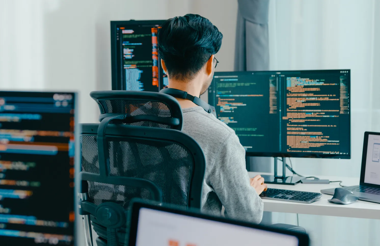 Young adult Asia male freelance eyeglasses typing write prompt AI bot IT app smart program nomad, video game, terminal with coding, user interface, designer, big data center on desktop computer.