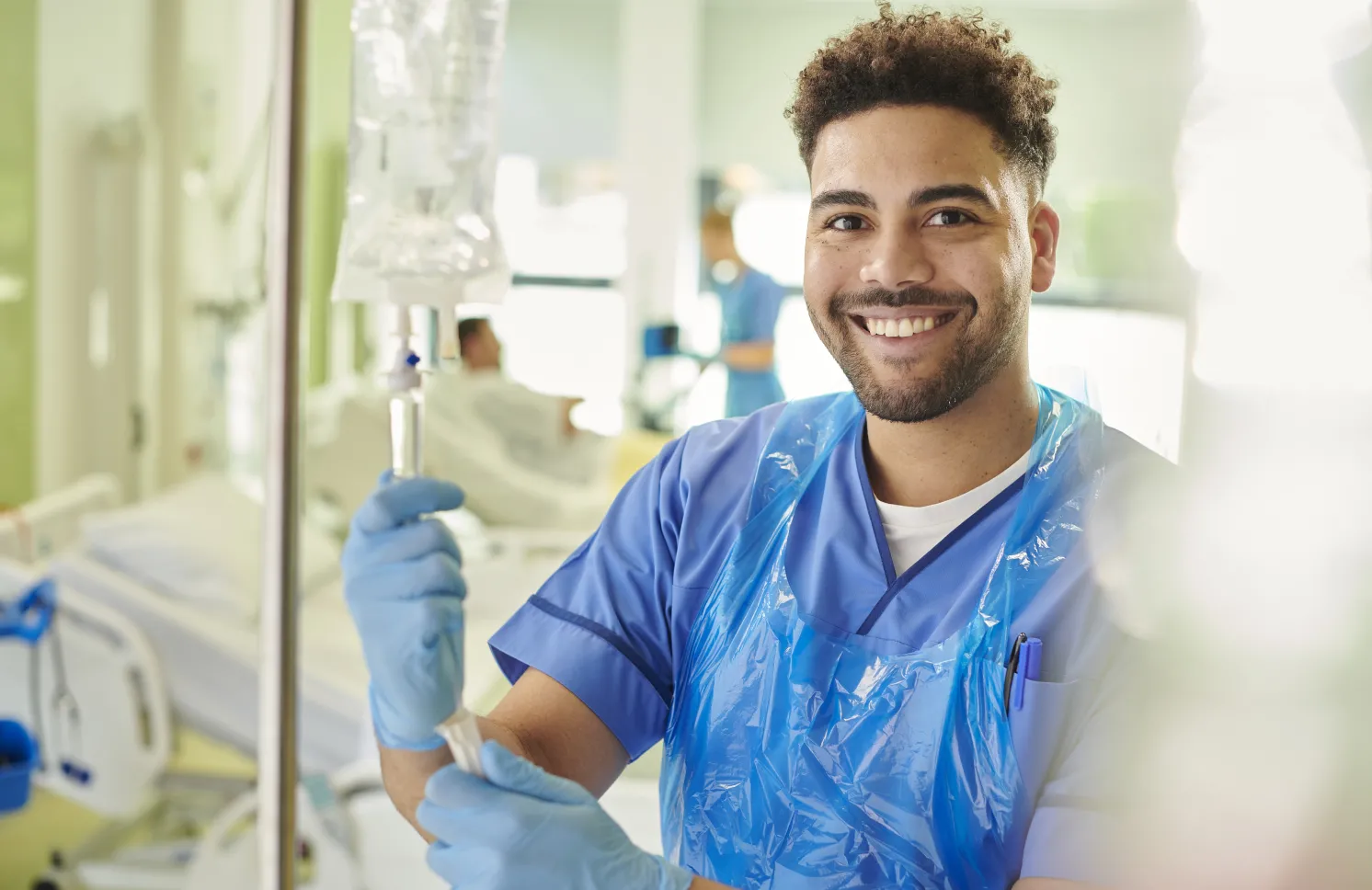 young male nurse adjusting iv drip