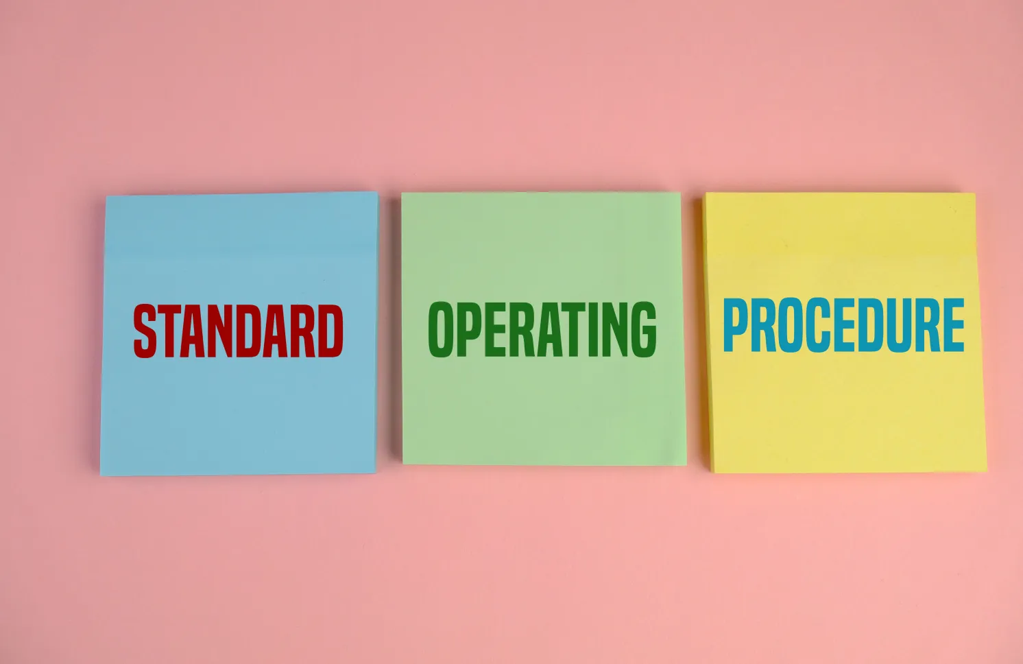Business Acronym SOP as Standard Operating Procedure. pink background. text on yellow, blue and green paper