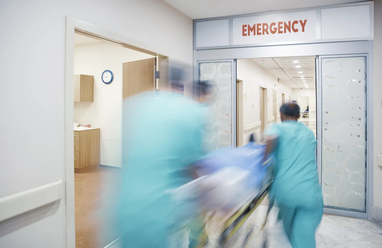 Nurses wheeling patient in emergency room