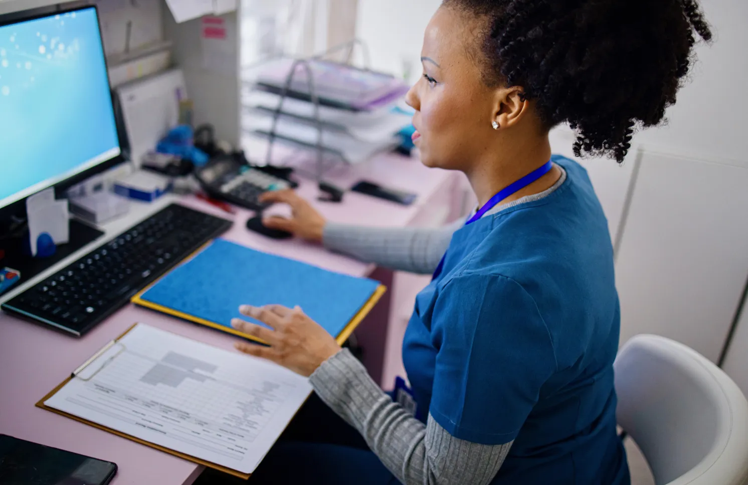 Black woman using computer to work as nurse in the private clinic.Black woman using computer to work as nurse in the private clinic.