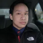 Man in a suit takes a selfie in a car