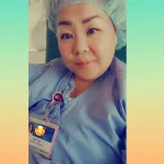 Woman poses for a selfie in full scrubs and cap