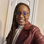 African American woman posing for a selfie in a leather jacket