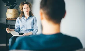 Psychiatric nurse practitioner speaking with client in an office environment