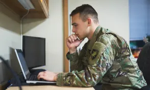 Shot of a young soldier using a laptop at a desk