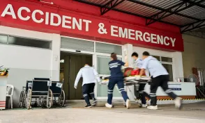 Team of emergency medical service workers wheeling patient on stretcher into the hospital during an emergency situation