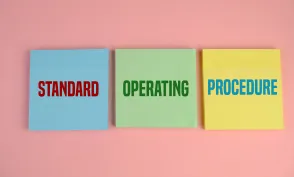 Business Acronym SOP as Standard Operating Procedure. pink background. text on yellow, blue and green paper