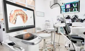 Interior of dental office with modern equipment and dental intraoral scanner with teeth on display, medical system for intraoral scanning. Concept of digital dentistry and dental scanning technology.