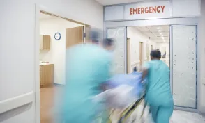 Nurses wheeling patient in emergency room