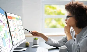 Project management team coordinating and update project planned schedule on computer