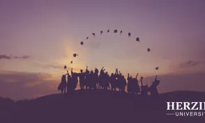 College graduates celebrating at sunset