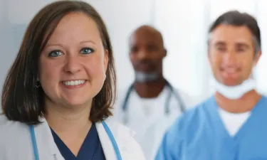 Online MSN Master's Degree Graduate Smiling with Hospital Staff
