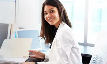 Medical Billing and Coding Specialist Smiling at Desk