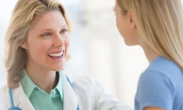 Family Nurse Practitioner with Post Master's Certificate Smiling at Young Patient