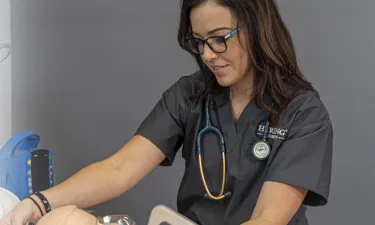 Nursing Student in Stethoscope Smiling in Nashville Nursing School Simulation Lab