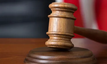 Gavel Resting on Bench with American Flag in Background