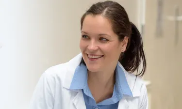 Nurse Practitioner Who Went From RN to MSN Online Smiling with Patient