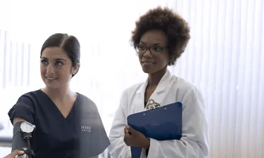 Nurse Teacher Who Went From BSN to Nurse Educator Instructing Student to Take Blood Pressure