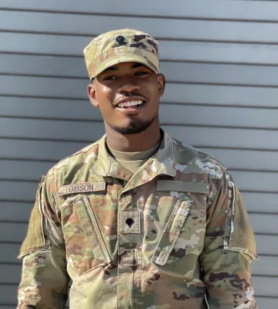 Herzing University male military student in Army uniform smiling outdoors, highlighting education support for servicemembers