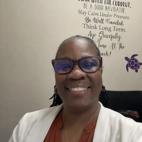 Professional African American nurse in a lab coat sitting in her office