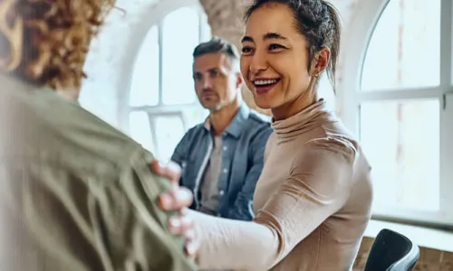 Health and Human Services Worker Smiling at Patient with Hand on Shoulder