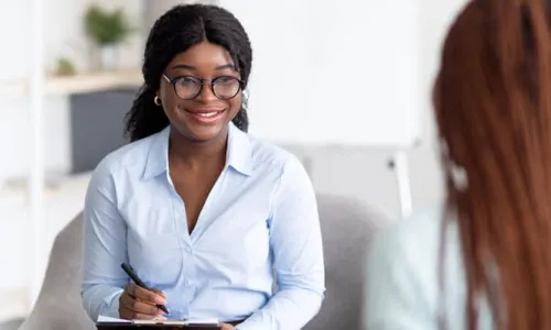 Substance Abuse Counselor with Psychology Degree Smiling with Client