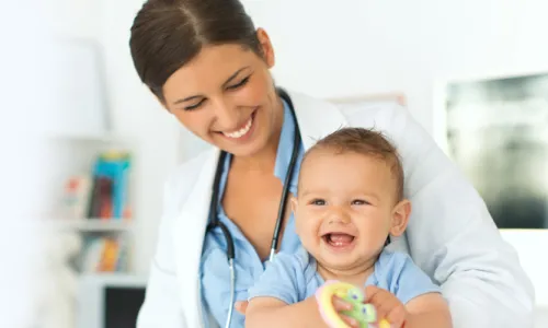 Pediatric Nurse Practitioner Smiling with Infant Patient in Appointment