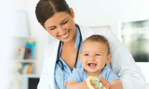 Pediatric Nurse Practitioner Smiling with Infant Patient