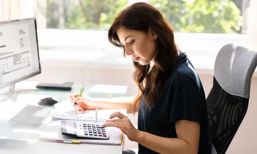 Accountant Seated at Desk Calculating Balances