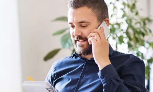 IT Manager Discussing Team Strategy On Phone In Office