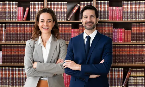 Legal Studies Graduates Smiling in Front of Bookshelves