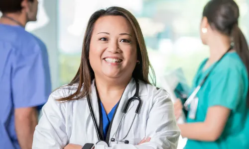Online MSN Master's Degree Graduate Smiling with Hospital Staff